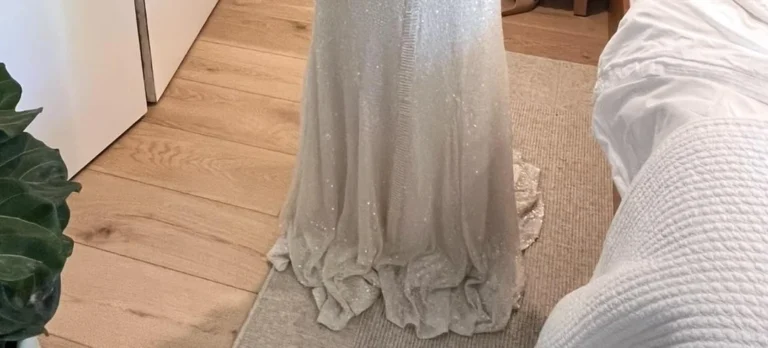 Мокрое шелковое платье лежит горизонтально на чистом белом полотенце для правильной сушки